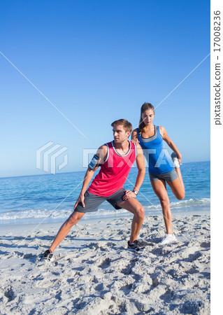 Happy couple stretching together beside the water Happy couple stretching together beside the water 17008236