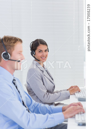 Business team working on computers and wearing headsets Business team working on computers and wearing headsets 17008239