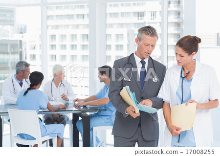 Male and female doctors with reports Male and female doctors with reports 17008255