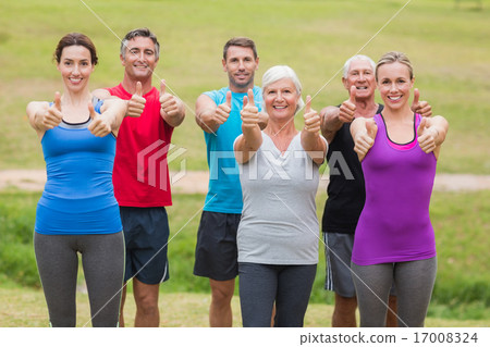 Happy athletic group smiling at camera with thumbs up Happy athletic group smiling at camera with thumbs up 17008324