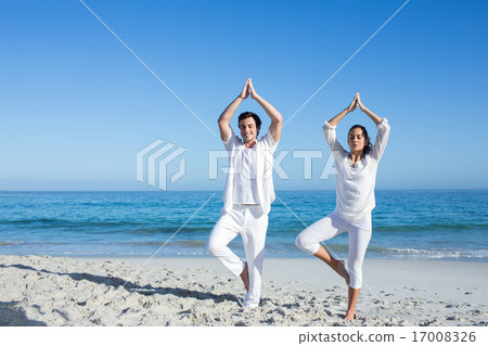 Happy couple doing yoga beside the water Happy couple doing yoga beside the water 17008326