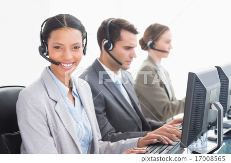 Business people with headsets using computers Business people with headsets using computers 17008565