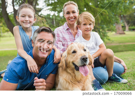 Happy family smiling at the camera with their dog 17009066