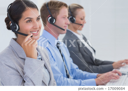 Stock Photo: Business team working on computers and wearing headsets