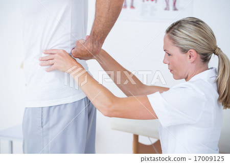 Doctor examining her patient back Doctor examining her patient back 17009125