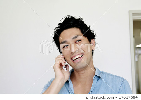 A young man calling with a smile A young man calling with a smile 17017684