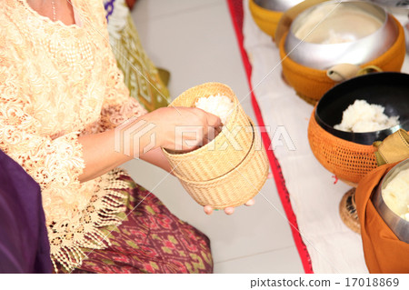 Hand taking sticky rice from bamboo container 17018869