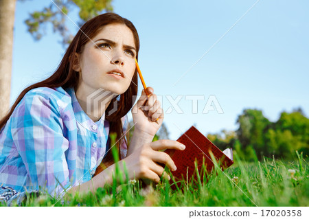 Beautiful girl in park with her diary Beautiful girl in park with her diary 17020358