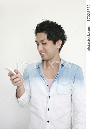 A young smiling male calling a mobile phone 17028752