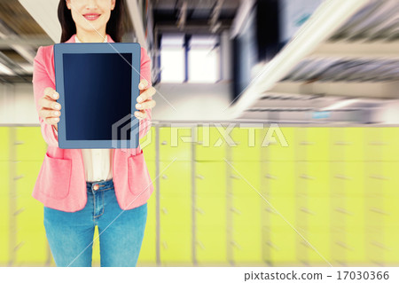 Composite image of elegant brunette using tablet 17030366