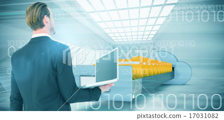 Composite image of businessman looking up holding laptop 17031082
