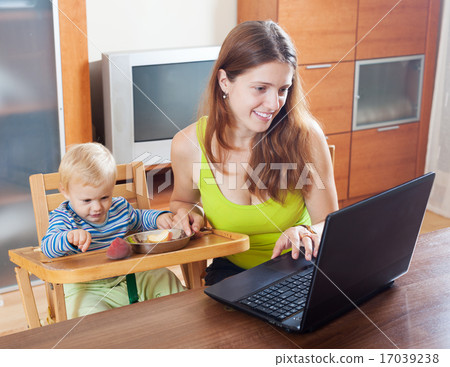 Happy young mother working with laptop 17039238