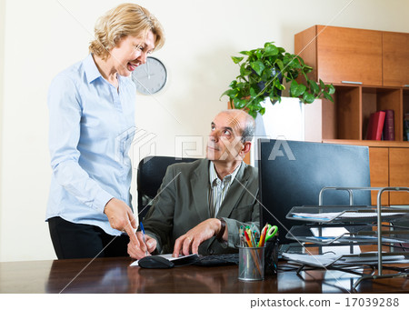 scene of two mature and smiling co-workers 17039288