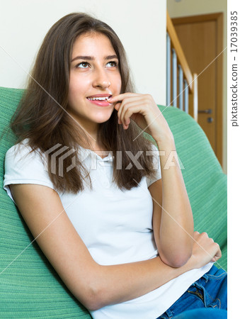 Girl sitting at sofa and biting nails 17039385