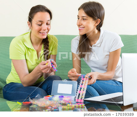 Girls making decorative bracelets 17039389