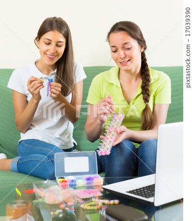 Girls making decorative bracelets 17039390