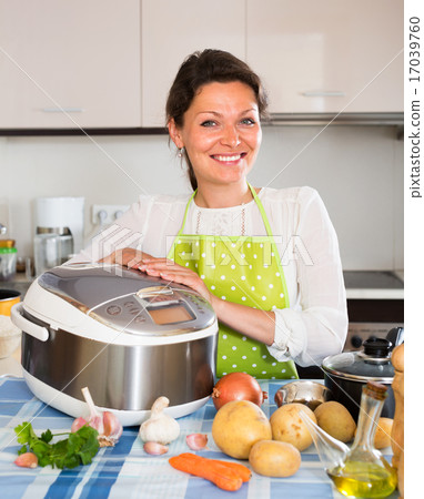 Happy woman using slo-cooker 17039760