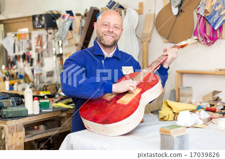 craftsman working with unfinished guitar 17039826