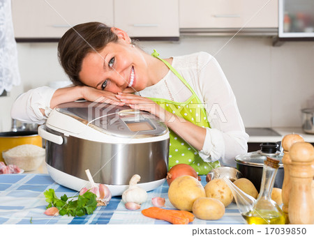Housewife cooking with multicooker. 17039850