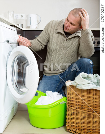 Sad guy using washing machine 17040287