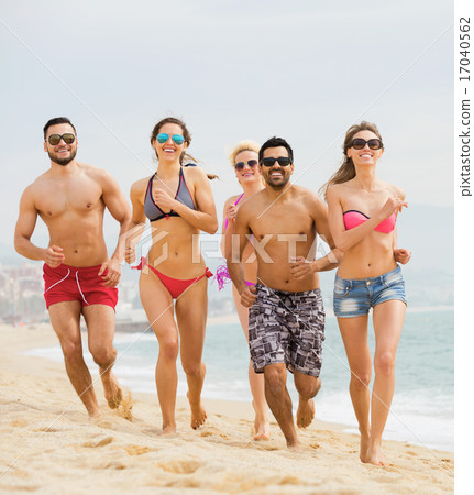 Active friends running at sandy beach 17040562