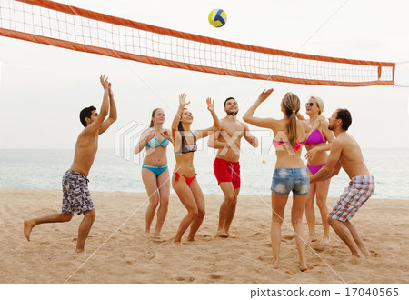 friends throwing ball over net and laughing friends throwing ball over net and laughing 17040565