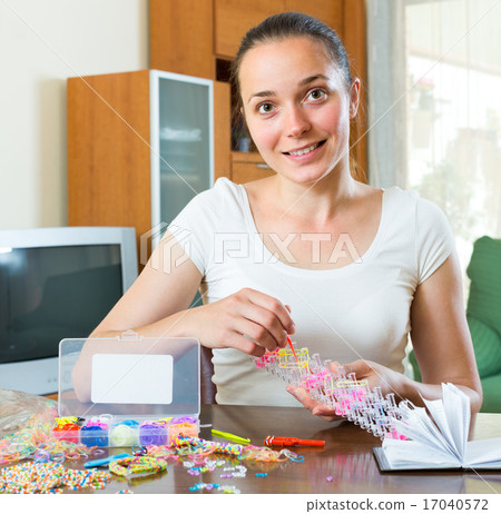 Girl makes decorative bracelet 17040572