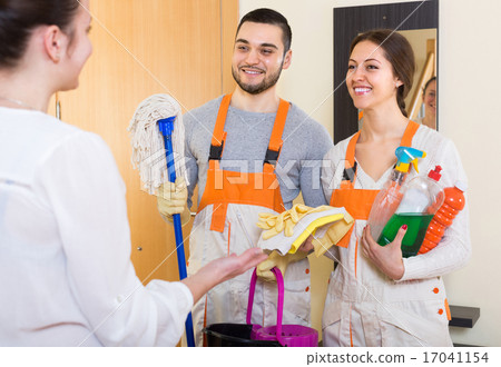 Housewife meeting cleaning crew at doorway. Housewife meeting cleaning crew at doorway. 17041154
