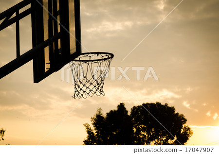silhouette of a basketball hoop, under the sunset. 17047907