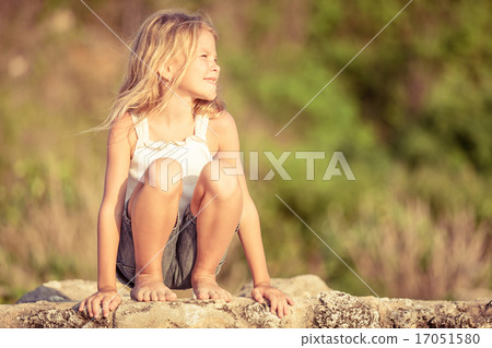 Happy Little girl  sitting on the beach 17051580