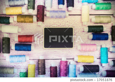 bobbins with colorful threads on old wooden table bobbins with colorful threads on old wooden table 17051876