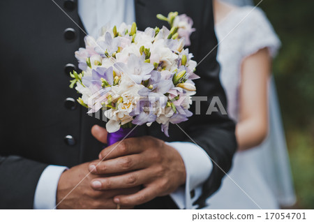 The groom holds a bunch of flowers 2046. The groom holds a bunch of flowers 2046. 17054701