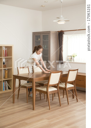 A woman doing housework in the dining room 17063281