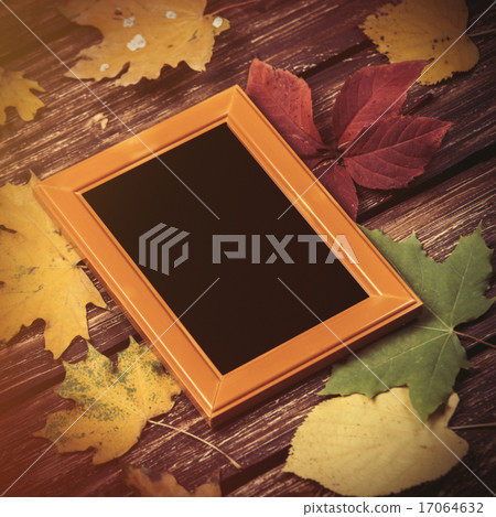 Autumn leafs and frame for photo on wooden table. Autumn leafs and frame for photo on wooden table. 17064632