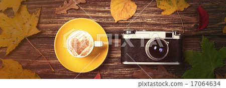 Autumn leafs, camera and coffee cup on wooden table. Autumn leafs, camera and coffee cup on wooden table. 17064634