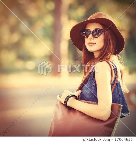 Beautiful redhead girl with bag in the park. Beautiful redhead girl with bag in the park. 17064635