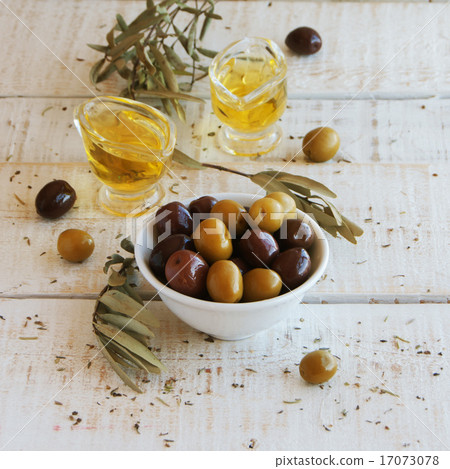 black and green olives, olive oil on a white wooden table black and green olives, olive oil on a white wooden table 17073078