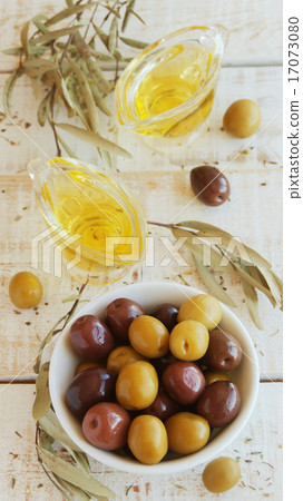 black and green olives, olive oil on a white wooden table black and green olives, olive oil on a white wooden table 17073080