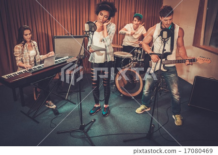 Multiracial music band performing in a recording studio Multiracial music band performing in a recording studio 17080469