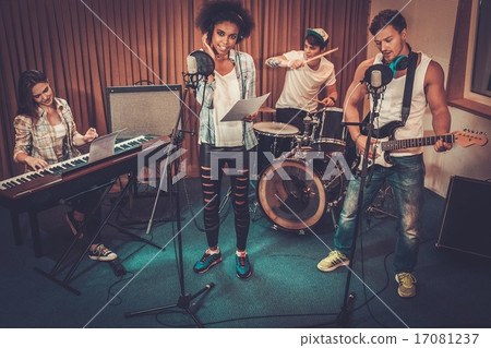 Multiracial music band performing in a recording studio Multiracial music band performing in a recording studio 17081237