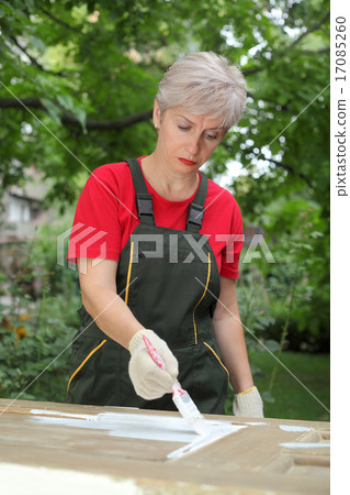 Female worker restoring old wooden door Female worker restoring old wooden door 17085260
