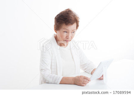 A senior woman looking at her face in the mirror 17089594