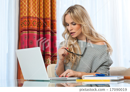 attractive blond woman writing on laptop attractive blond woman writing on laptop 17090019