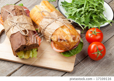Two sandwiches with salad, ham, cheese and tomatoes 17109116