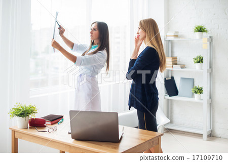 Doctor woman with white labcoat looking at x-ray radiographic results ct scan mri in  hospital 17109710