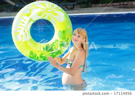 Pregnant woman with green rubber ring in swimming pool 17114956