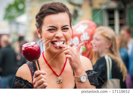 Attractive woman holding a red caramelized apple at the Oktoberfest 17118652