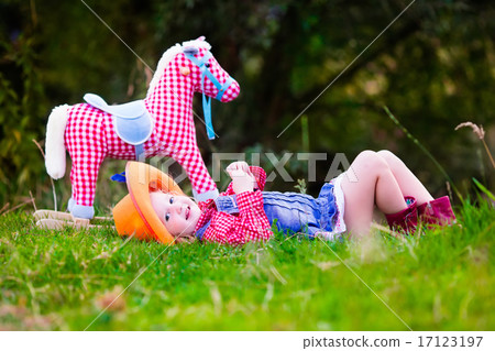 Little girl playing with toy horse in cowboy costume 17123197