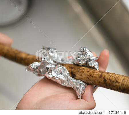 Using aluminum foil to peel the skin off the burdock root. Using aluminum foil to peel the skin off the burdock root. 17136446