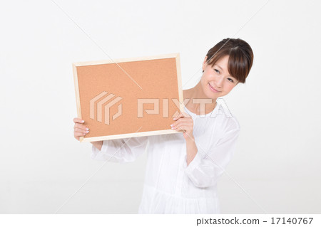 A woman holding a cork board with a smile A woman holding a cork board with a smile 17140767